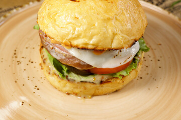 Juicy burger with beef tongue close-up. Selective focus