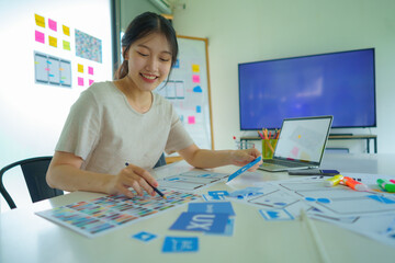 A website designer or Creative woman planning phone app development sketch template layout...