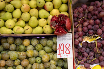 Vista de unas cestas de fruta con su etiqueta y precio en una frutería de barrio.