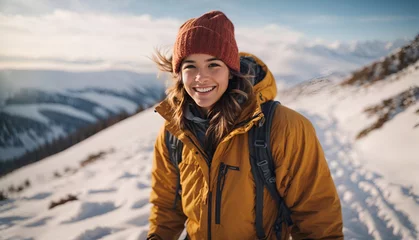 Fotobehang Winter hike on snowy mountain young girl orange shirt wool hat cheerful happy hiker climbs the top. natural landscape. Winter journey. © New generate
