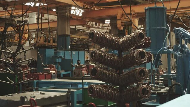 Closed plant with metalworking equipment and storage facilities for processed parts. Non-working abandoned factory with old equipment and pneumatic tools without people.