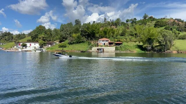 Wealthy motorboat sailing Guatape reservoir at sunny day