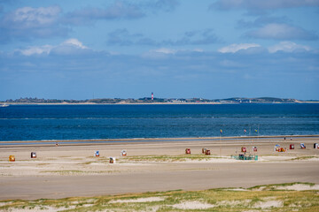 Blick aus den Dünen von Norddorf auf Amrum über den feinen breiten Sandstrand am Horizond Blick auf die Insel Sylt mit dem Leuchtturm von Hörnum