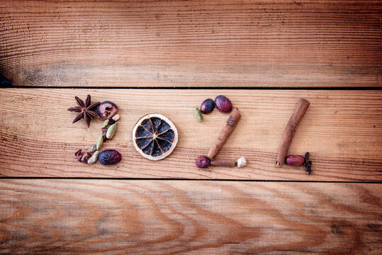 2024 written with Christmas spices and dried fruits on wooden background, new year greeting card