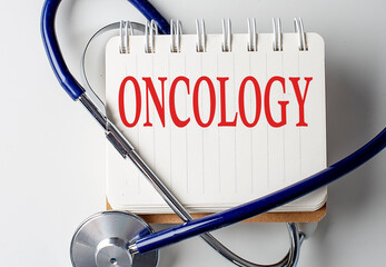 ONCOLOGY word on notebook with medical equipment on background