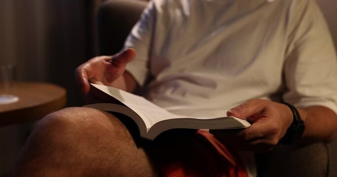 Man hands flip through pages of reading books in evening at home. Reading an interesting book