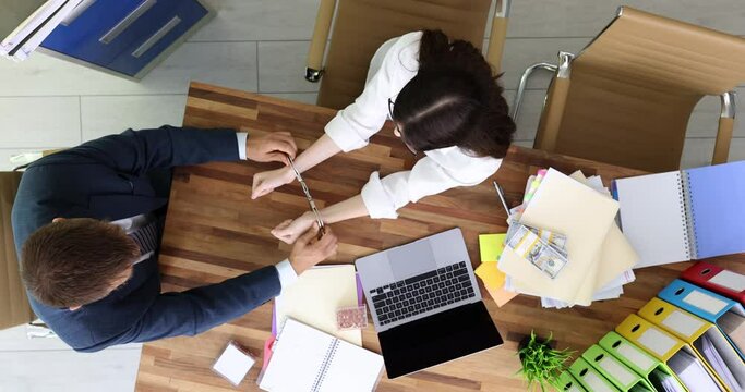 Man handcuffs woman with dollars at workplace top view. Anti-corruption and bribe concept