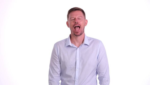Portrait of handsome young man yawning on white background. Fatigue drowsiness and overwork