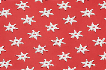 White snowflake Christmas ornament flat lay on red background