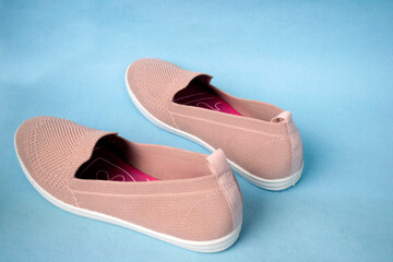 a pair of pink women's casual shoes on a blue background