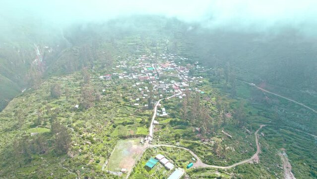 Drone shot: Tapay emerges from the clouds. Unique perspective, Andean village, remote beauty