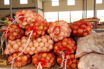 Bunches of onions are placed on top of each other, including white onions and normal onions