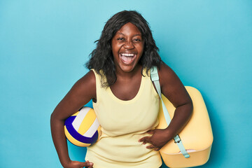 Young curvy woman with cooler and ball laughing and having fun.