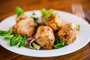 Fried pieces of chicken fillet breaded with spices and herbs in a plate .