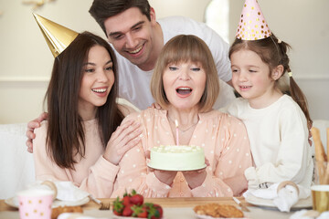 Family son his wife and granddaughter celebrate grandma birthday