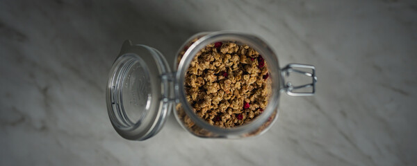 Granola in a jar. Homemade muesli with raspberries. Healthy eating concept
