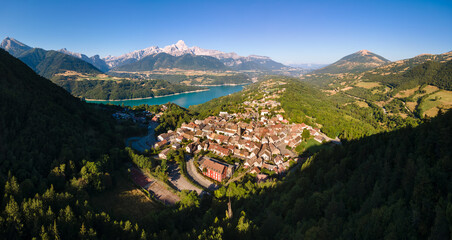 Aerial view of the village of Corps with Sautet Lake. In the distance, the higest point in Devoluy mountain range, the Obiou peak. Isere, Alps, France - obrazy, fototapety, plakaty