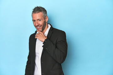 Businessman in formal attire on blue studio background