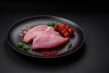 Raw turkey meat in the form of slices with salt, spices and herbs