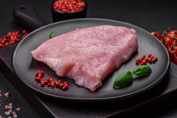 Raw turkey meat in the form of slices with salt, spices and herbs