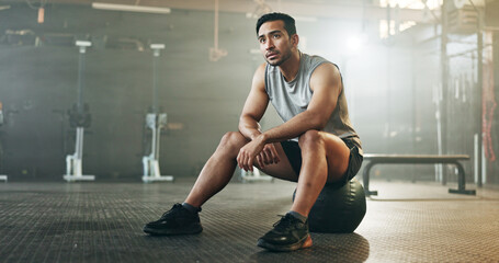 Fitness, breathing and sweating with a tired man in the gym, resting after an intense workout. Exercise, health and fatigue with a young athlete in recovery from training for sports or wellness - Powered by Adobe