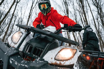 Two people are riding ATV in the winter forest © standret