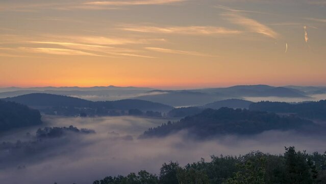 Time lapse of thick moving fog in valleys of Bavarian Forest near Regensburg during dawn and sunrise