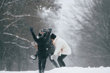 Obraz premium Playing snowballs. Happy family is outdoors, enjoying snow time at winter together