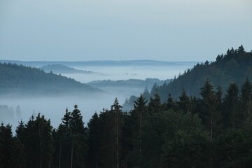 Scenic view of a beautiful landscape with valleys and mountains seen on a foggy day