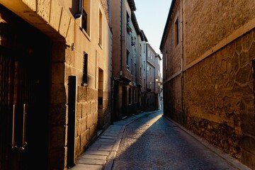 Narrow stone path with buildings on a sunny day