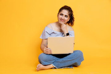 indian girl sitting using laptop thoughtful expression isolated on color background