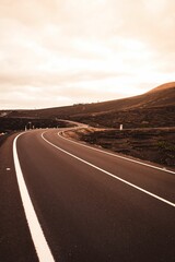 Vertical shot of the narrow highway between the hills and mountains