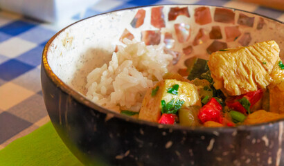 Oriental chicken stew with rice served in a rustic bowl. Exotic food. Close up. Selective focus