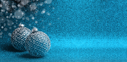 Blue Christmas background. Baubles decoration with ornament, xmas tree brunch, sparkles, copy space. Winter holiday theme. New Year or Merry christmas greeting card.