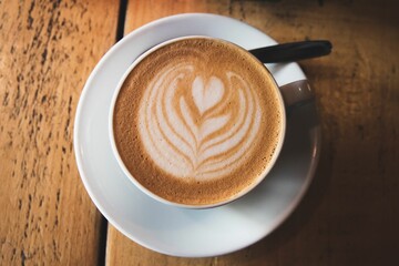 Closeup of latte coffee on the wooden  table with a blurry background