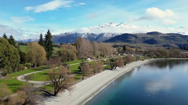Wanaka, New Zealand: Aerial footage of the camping area by the beach of the Glendhu Bay by lake Wanaka with the snow covered Mt Aspiring in New Zealand south island. 