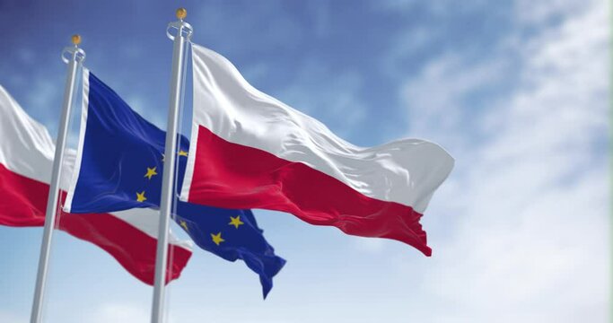 Flags of Poland and the European Union waving in the wind on a clear day