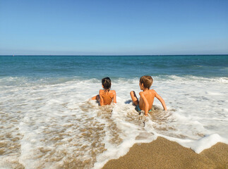 children playing with the waves on a beach in cabo de gata