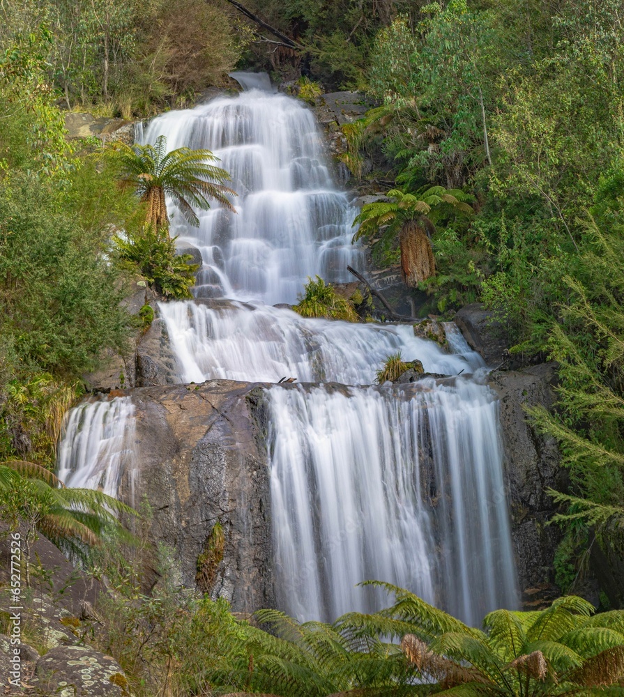 Sticker Majestic waterfall cascades down a lush green backdrop, creating a picturesque and serene atmosphere