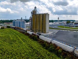 Aerial view of a long cargo train near a farm in Delaware on a sunny day