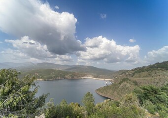 Aerial view of the Atazar reservoir in Madrid surrounded by vegetation and mountains, Spain