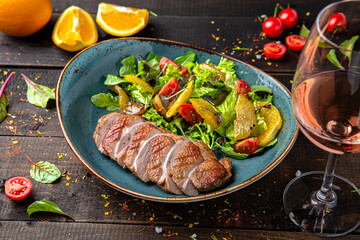 Duck fillet with orange salad, avocado. Menu for a restaurant. Beautiful composition on wooden boards.