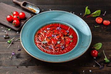 Cold soup of tomatoes, baked peppers. Menu for a restaurant. Beautiful composition on wooden boards.