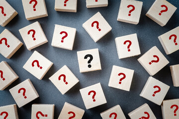 Many question mark signs on the wood cubes scattered, with only important question at the center