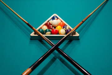 Billiard accessories balls and cross cue on a billiard table