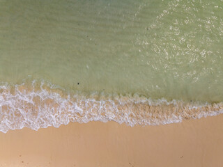 Summer sea nature background,Aerial view of Waves crashing on sandy shore,Sea surface ocean waves background