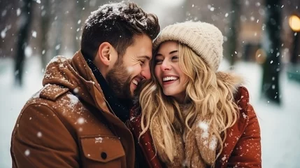 Fotobehang Young romantic couple is having fun outdoors in winter before Christmas. Enjoying spending time together in New Year Eve. Two lovers are hugging and kissing in Saint Valentine's Day. © Nataliia