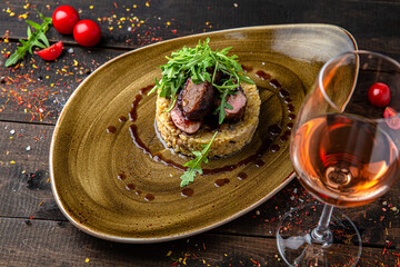 Risotto with mushrooms and beef steak. Menu for a restaurant. Beautiful composition on wooden boards.