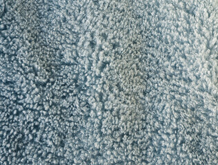 Fluffy fur fabric macro texture for background. Fuzzy fabric for winter day. Blue fur, winter fabric textile. Soft furry blue fabric background. Super soft, vela, plush. Fluffy effect. Soft blue color