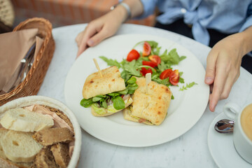 Healthy chicken and spinach sandwiches and fresh vegetable salad on the table at city cafe. Healthy diet food concept. for breakfast or lunch. Vegetarian food. Vegan menu. Long banner format. High